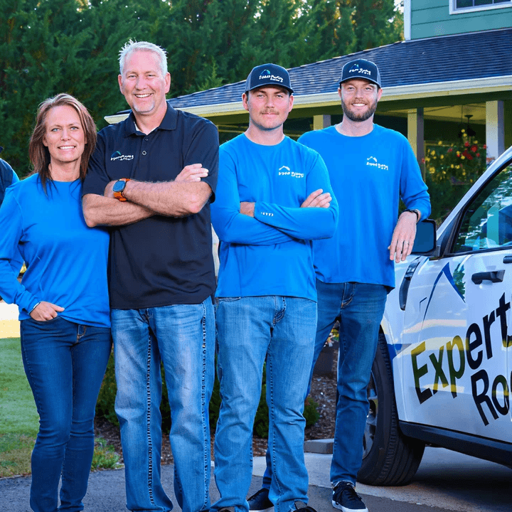 The Expert Roofing Services team stands in front of a truck.