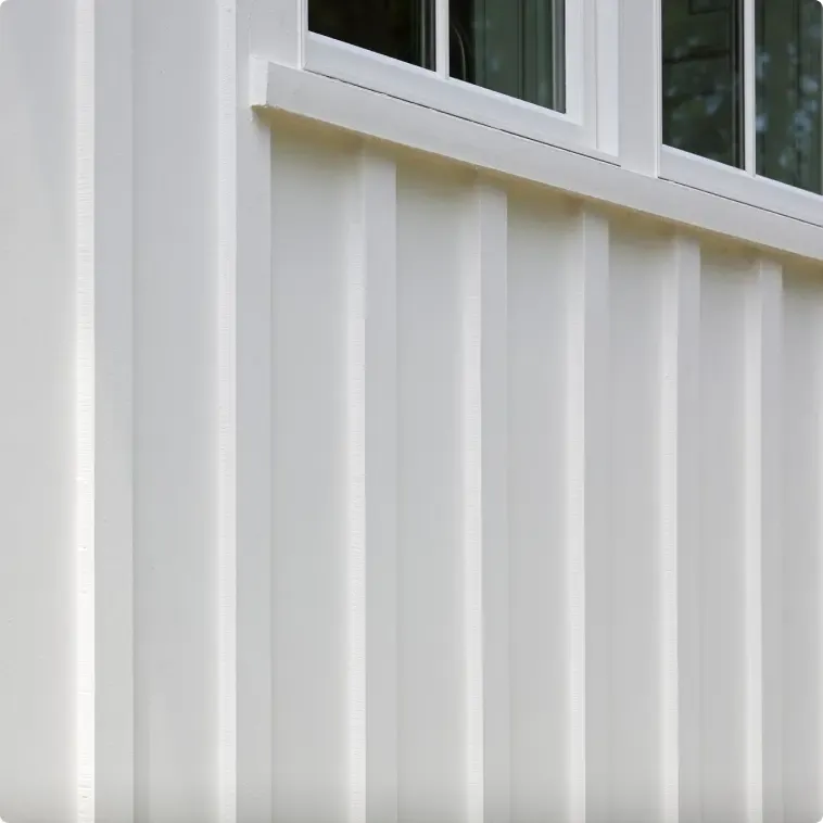 Close-up of a white board and batten exterior wall with vertical lines and a window above.